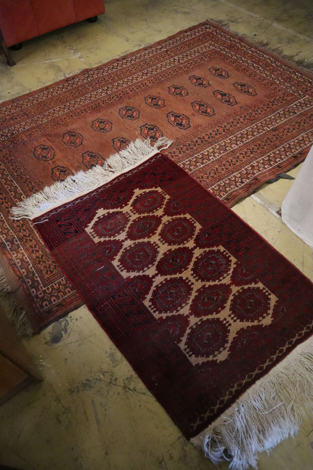 A Bokhara brick red ground rug, 217 x 147cm and a similar later rug, 110 x 74cm